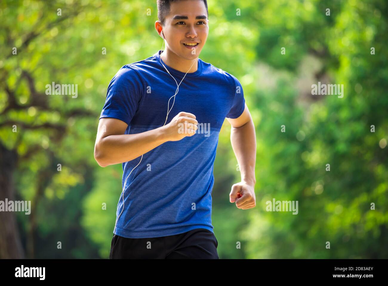 Junger Mann in Fitnesskleidung und Laufen im Park Stockfoto