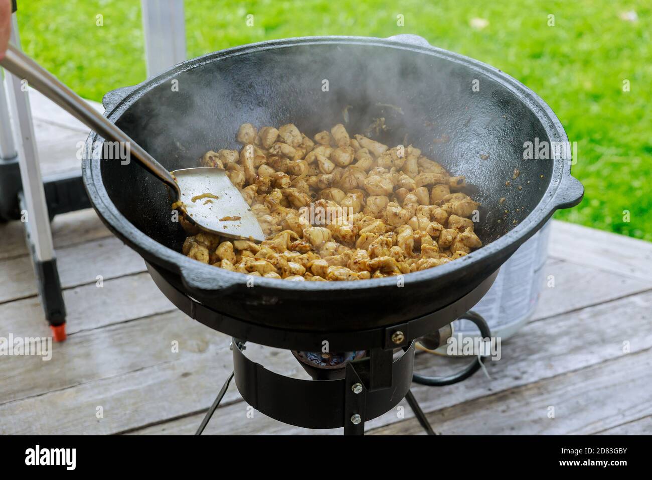 Prozess des Kochens Gulasch in einem Kessel im Freien. Das Fleisch wird gebraten. Stockfoto