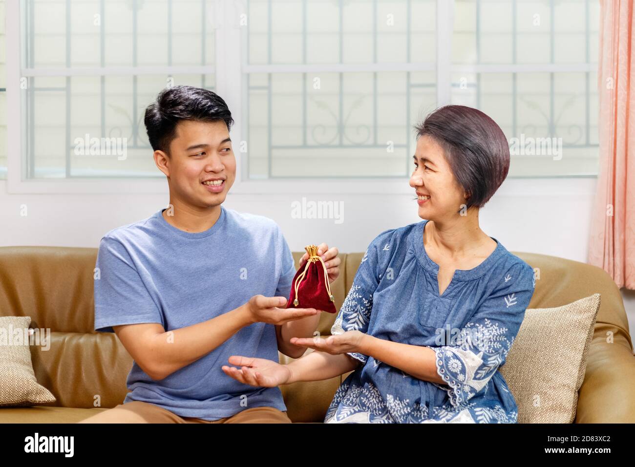 Erwachsene Sohn gibt ein Geschenk an die Mutter auf die Mütter Tag Stockfoto