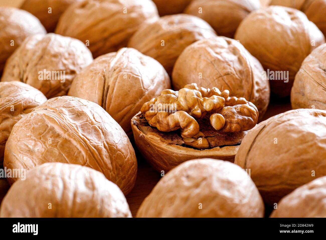 Nahaufnahme von geschälten Walnuss zwischen Walnüssen in Schale Hintergrund Muster Stockfoto