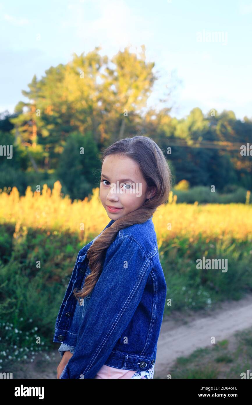 Das schöne Teen Girl lächelt und genießt die Natur im Park bei Sonnenuntergang Stockfoto