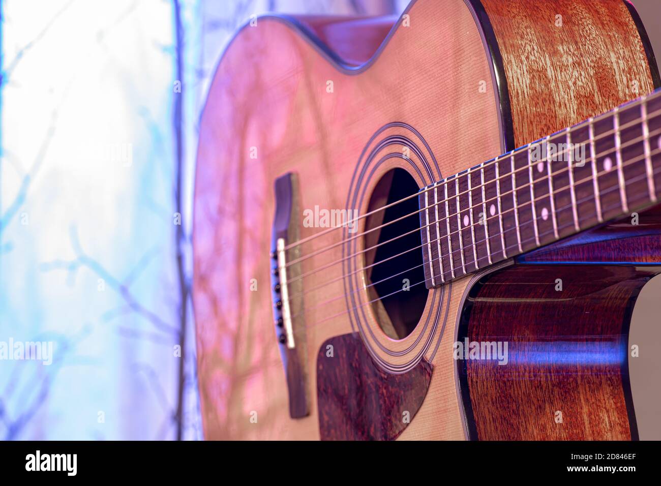 Akustische Gitarre auf einem schönen farbigen Hintergrund. Das Konzept der Saiteninstrumente. Nahaufnahme. Stockfoto