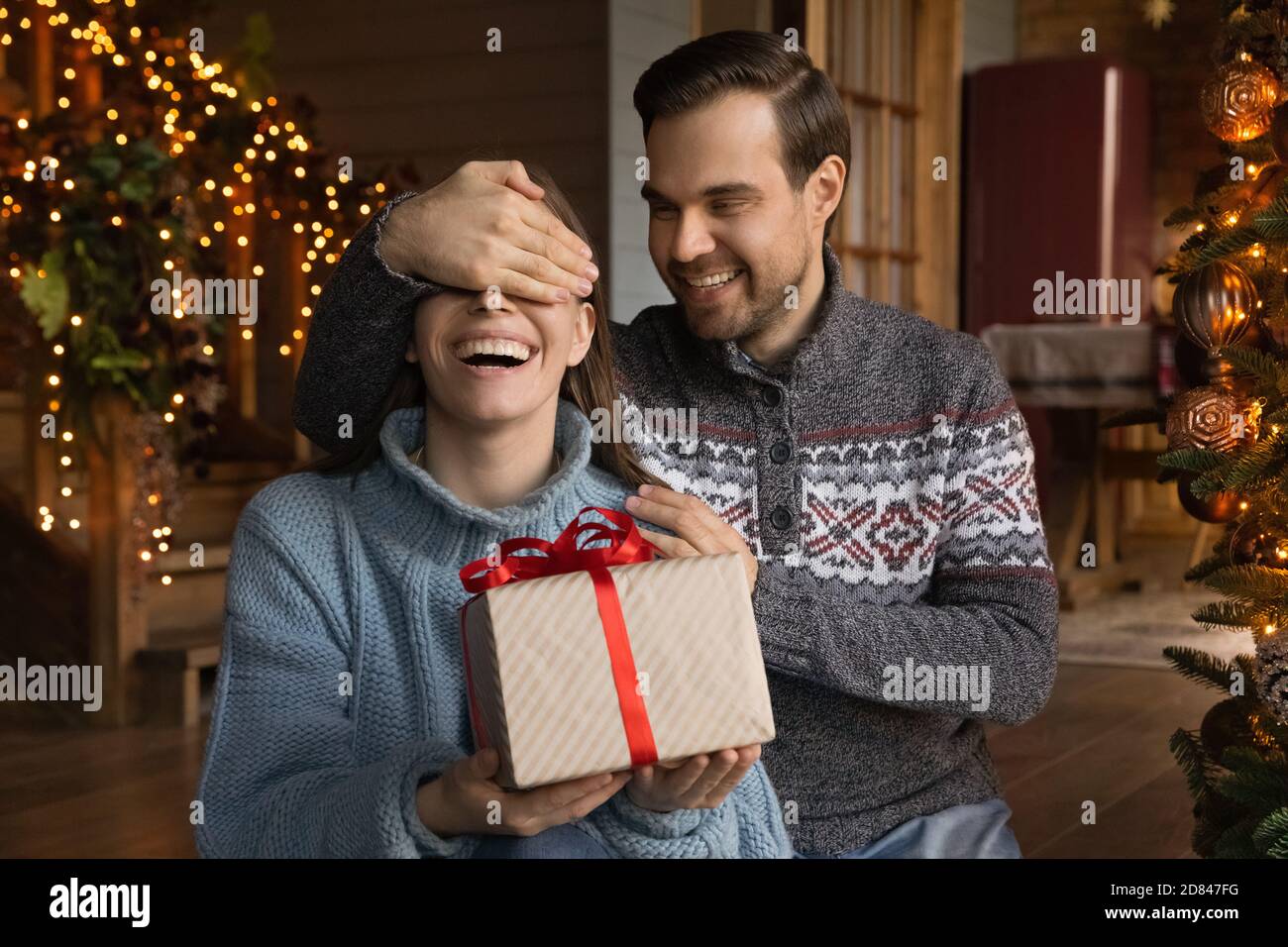 Liebevoller Ehemann gratuliert aufgeregt Frau mit Neujahr Stockfoto