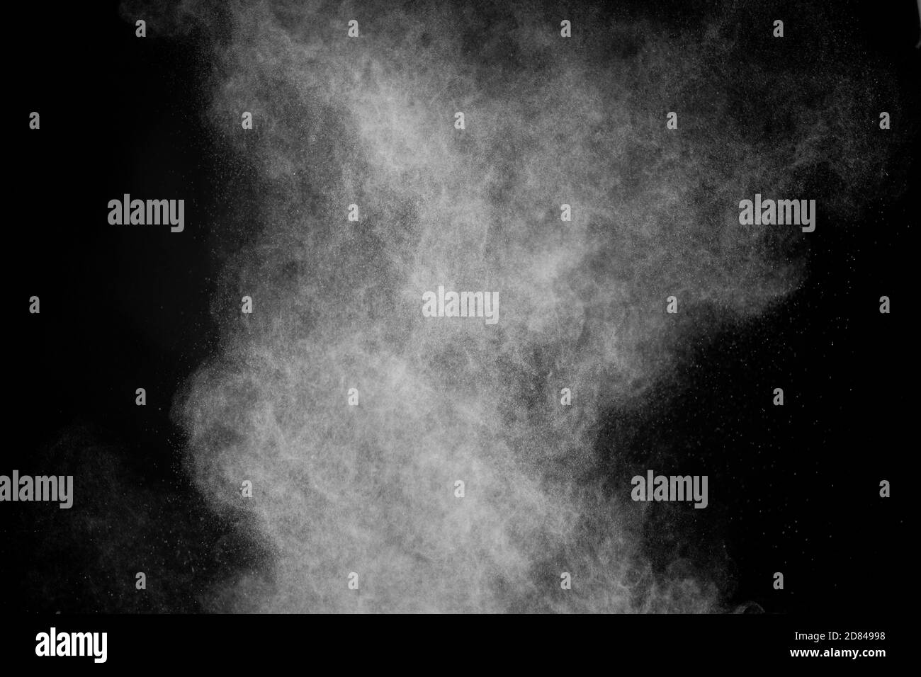 Fliegendes weißes Pulver auf isoliertem schwarzen Hintergrund, Hurrikan Sturm Staub Konzept Stockfoto