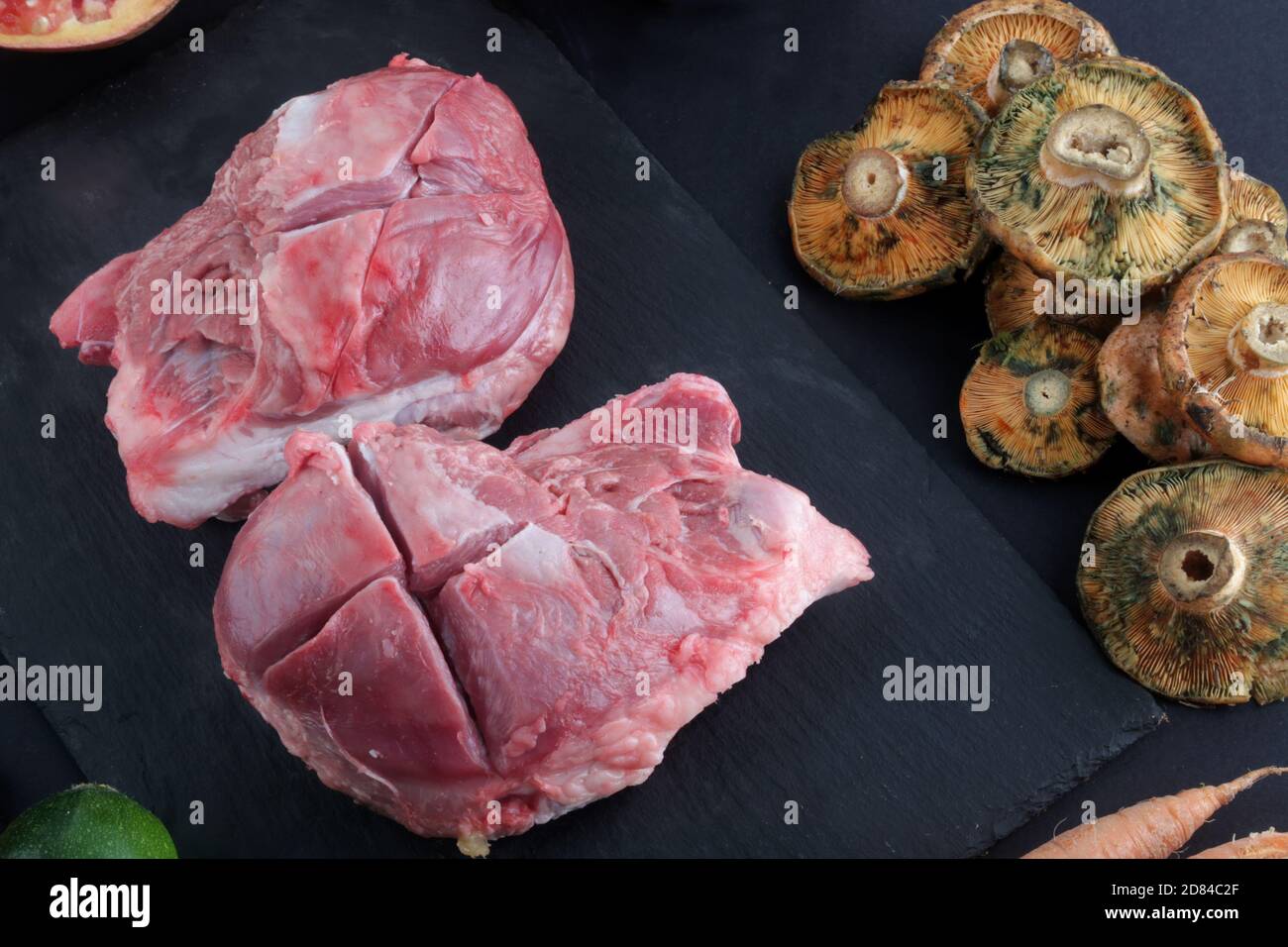 Rohe Schweinebäcken mit Pilzen Stockfoto
