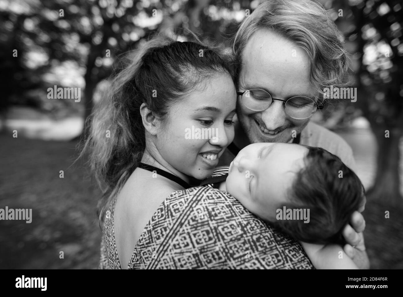 Multiethnische junge Familie verbindet sich im Park Stockfoto