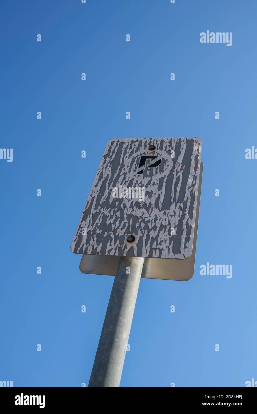 Heiße Sonne beschädigt kein Parkplatz Schild gegen einen klaren blauen Himmel. Stockfoto