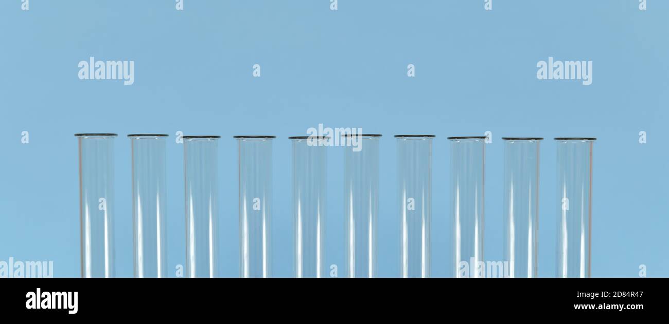 Die Hälse leerer Glasröhrchen, aufgereiht auf blauem Hintergrund. Stockfoto