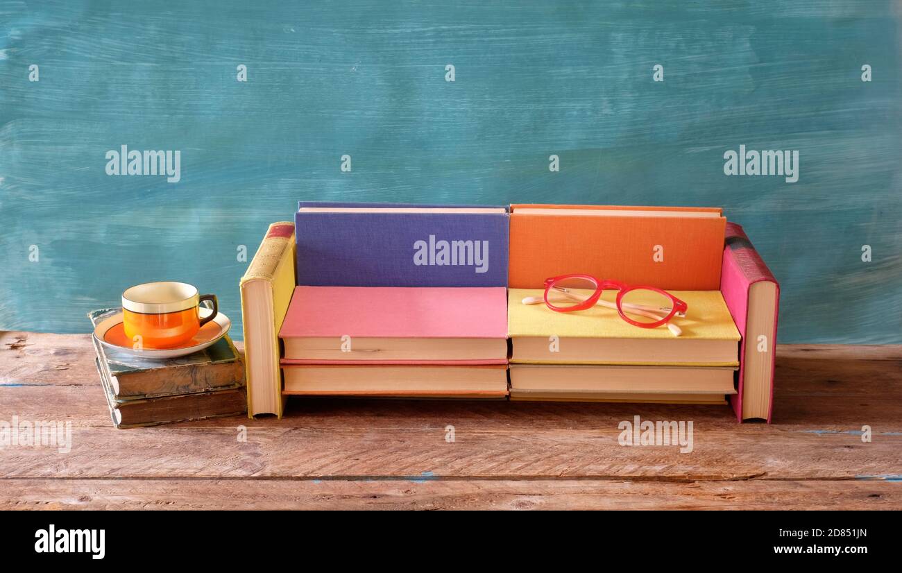 Arrangement von Büchern, Kaffee und Brille und einem Sofa. Lesen, Literatur, Bildung, Realxing Konzept, guter Kopieplatz Stockfoto
