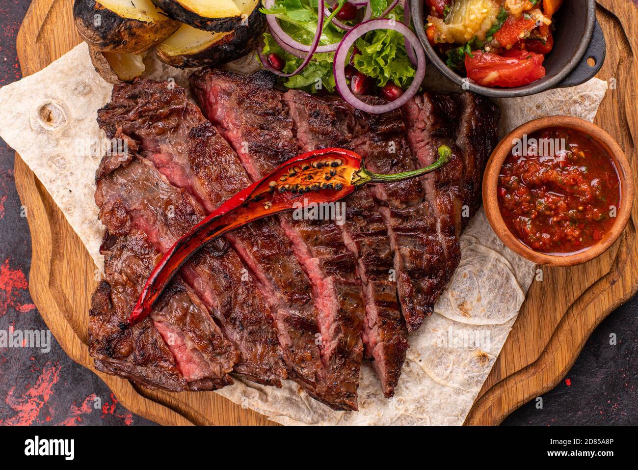 Gemischte gegrillte Fleischplatte. Sortierte lecker Gegrilltes Fleisch mit Gemüse. Gemischte gegrilltes Fleisch mit Pfeffer Soße und Gemüse. Stockfoto