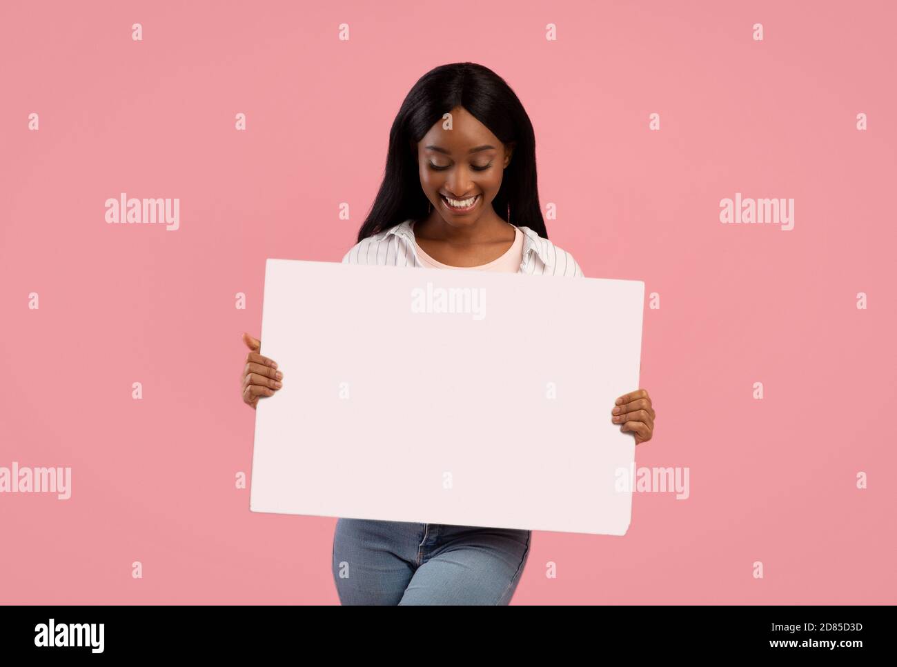 Tolle Promotion. Glückliche afroamerikanische Frau hält leere Banner mit leerem Raum auf rosa Hintergrund Stockfoto