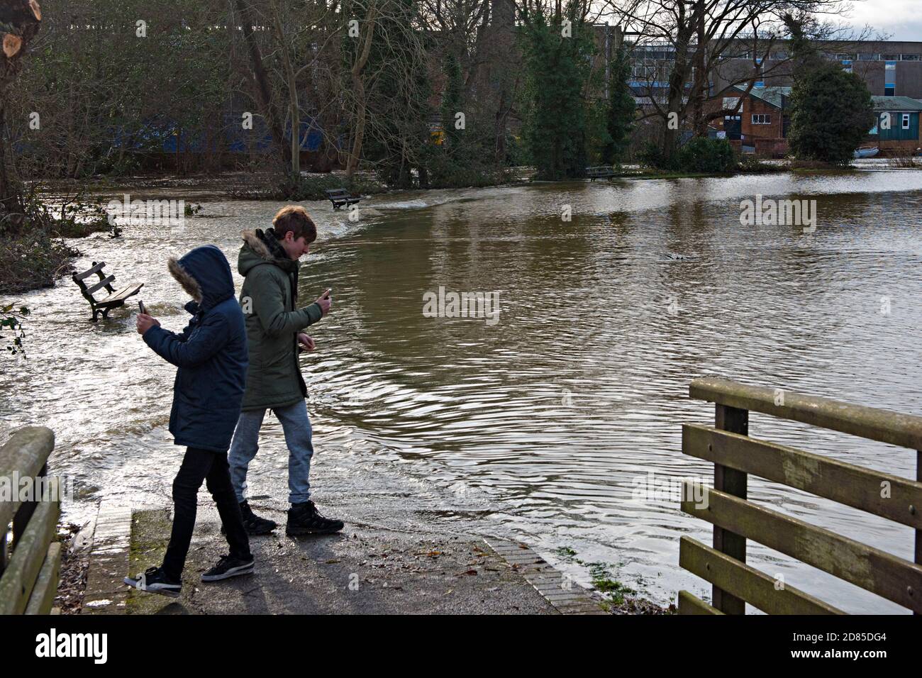 Kinder schauen sich den überfluteten Sportplatz in Tonbridge, Kent, Großbritannien, nach einer Überschwemmung durch den nahe gelegenen Fluss Medway an Stockfoto