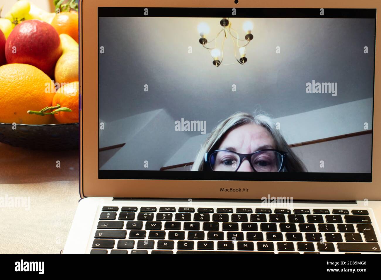 Videointeraktion heute. Zoom Videokonferenz Problem im Heimbüro auf MacBook Air mit verschwommenem Kopf und Hängeleuchte in der Aufnahme. Stockfoto