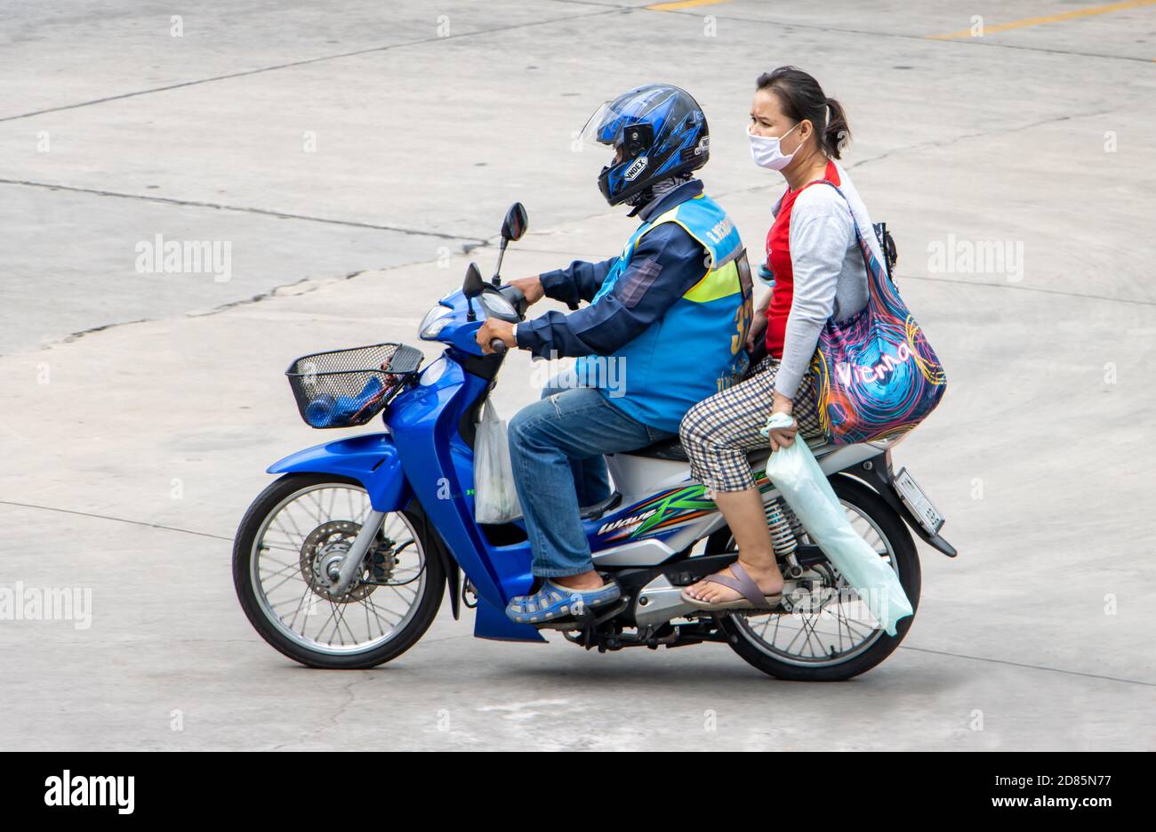 SAMUT PRAKAN, THAILAND, JULI 25 2020, EIN Taxifahrer auf einem Motorrad fährt mit einer Frau. Der mototaxi-Fahrer trägt einen Passagier. Stockfoto