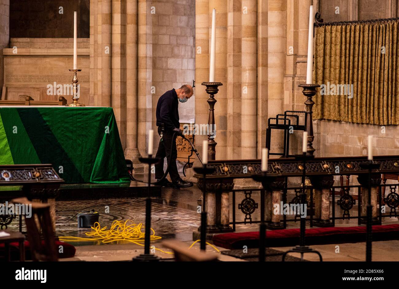 Mann trägt Gesichtsmaske Reinigung Kathedrale, Norwich Kathedrale, Norwich, Norfolk, Großbritannien Stockfoto