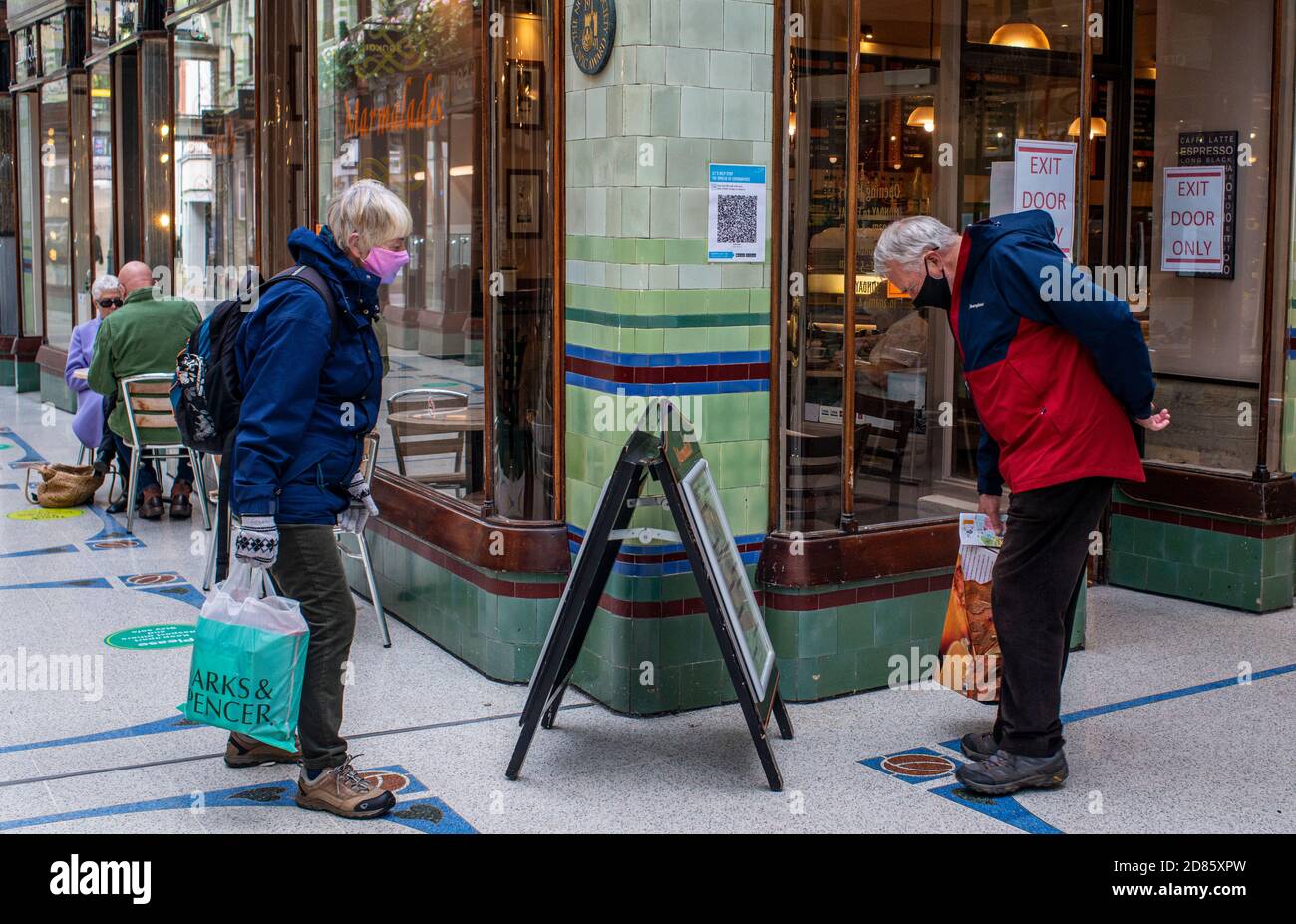 Mann und Frau lesen Schild vor Shop, Royal Arcade, Norwich, Norfolk, Großbritannien Stockfoto