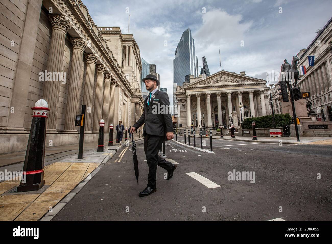 Cheapside Business Ambassador oder Welcome Ambassador überquert die Bank Junction mit der Royal Exchange und der Bank of England im Hintergrund, City of London. Stockfoto