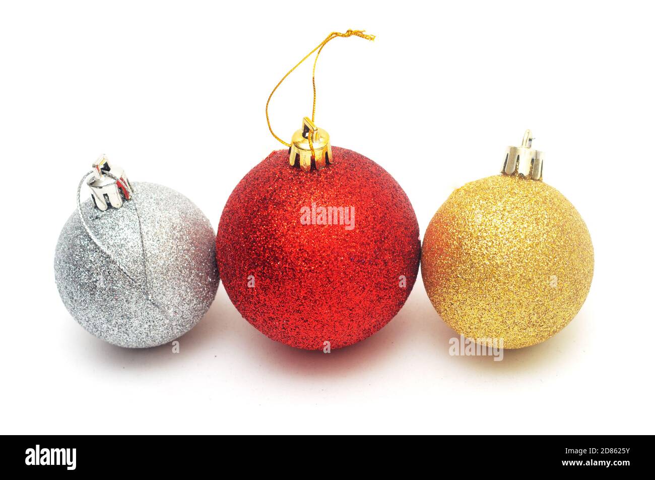 Drei Weihnachtskugeln isoliert auf weißem Hintergrund.Rote, goldene und silberne Kugeln Stockfoto