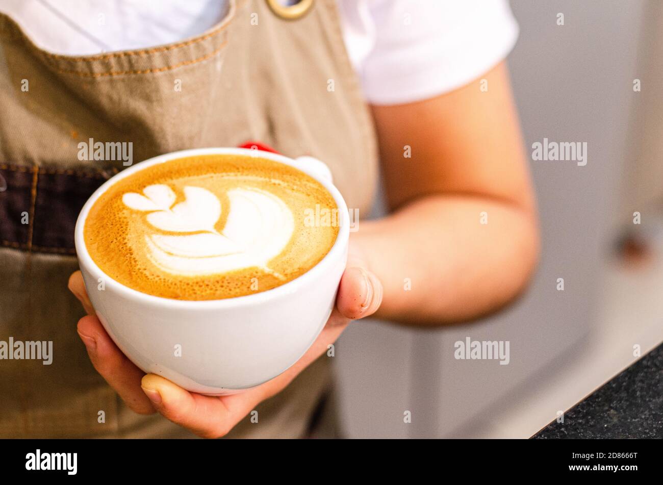 Peruanische weibliche Barista schaffen Latte Art in Coffee Shop, Essen und Trinken Konzept Stockfoto