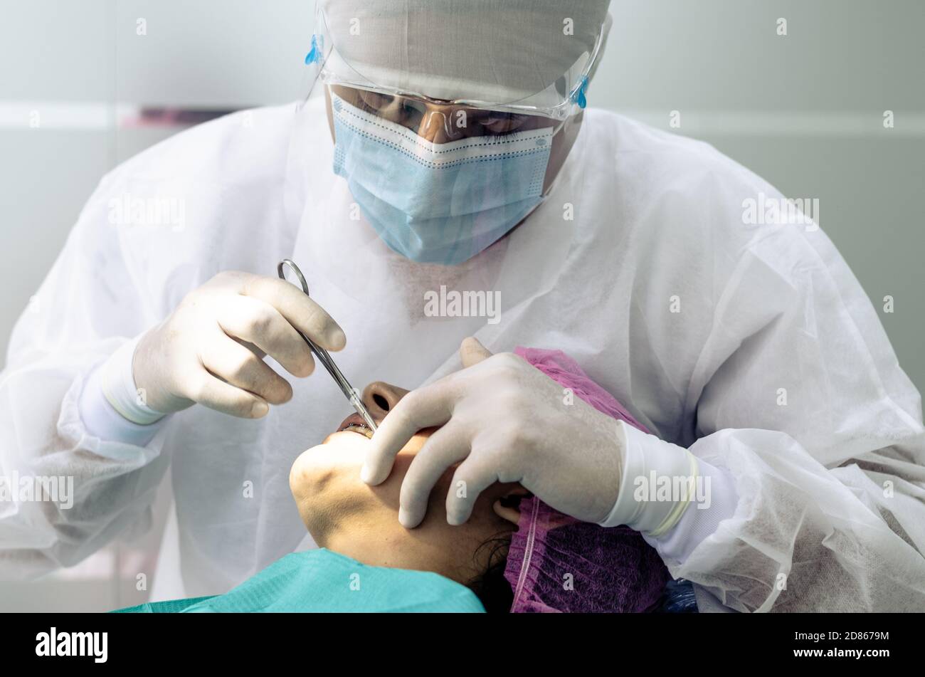 Der Zahnarzt oder Arzt trägt im Hintergrund der Zahnarztpraxis einen weißen  medizinischen Kittel, eine Maske und eine Schutzbrille. Gesundheits- und  Schutzkonzept Stockfotografie - Alamy