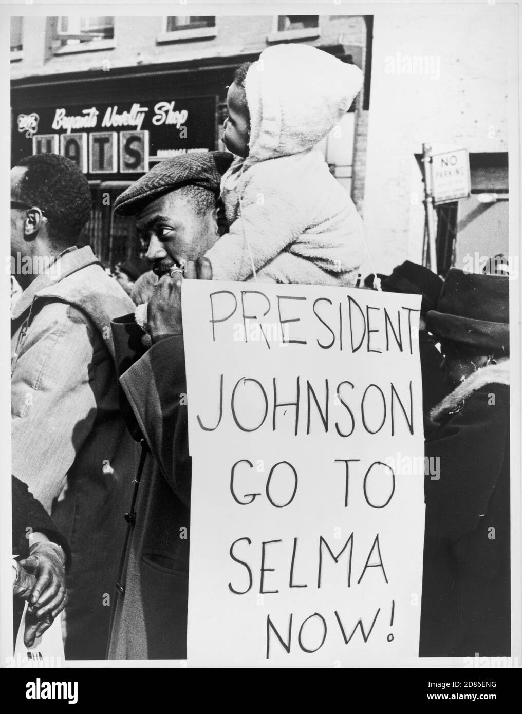 Ein afroamerikanischer Mann hält ein Kind auf seinen Schultern, während er ein Schild trägt, das Präsident Lyndon Johnson sagt: 'Go to Selma Now', New York, NY, 3/1965. (Foto von Stanley Wolfson/New York World-Telegram und The Sun Newspaper Photograph Collection/RBM Vintage Images) Stockfoto