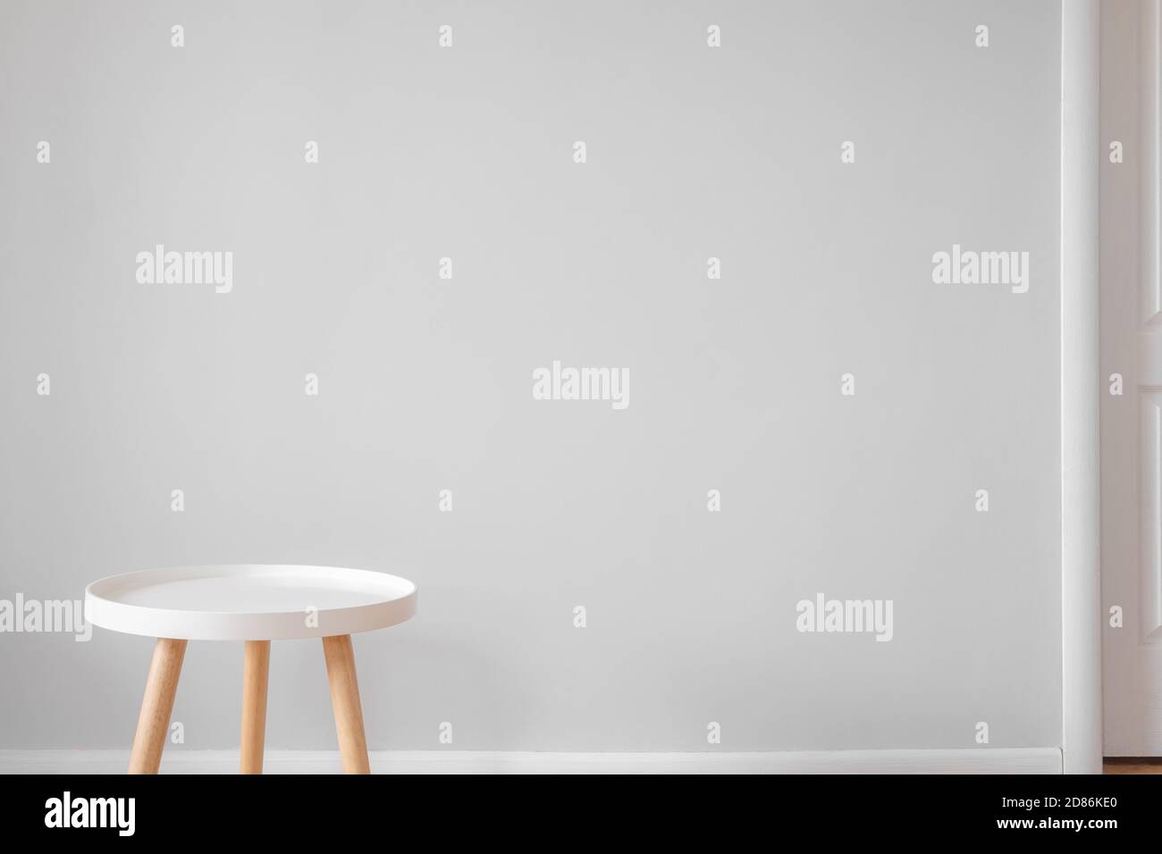 Leerer weißer Couchtisch vor einer grauen Wand in einem Zimmer. Skandinavischer Innendesign, Minimalismus im Haus, ruhiges Wohnkonzept Stockfoto