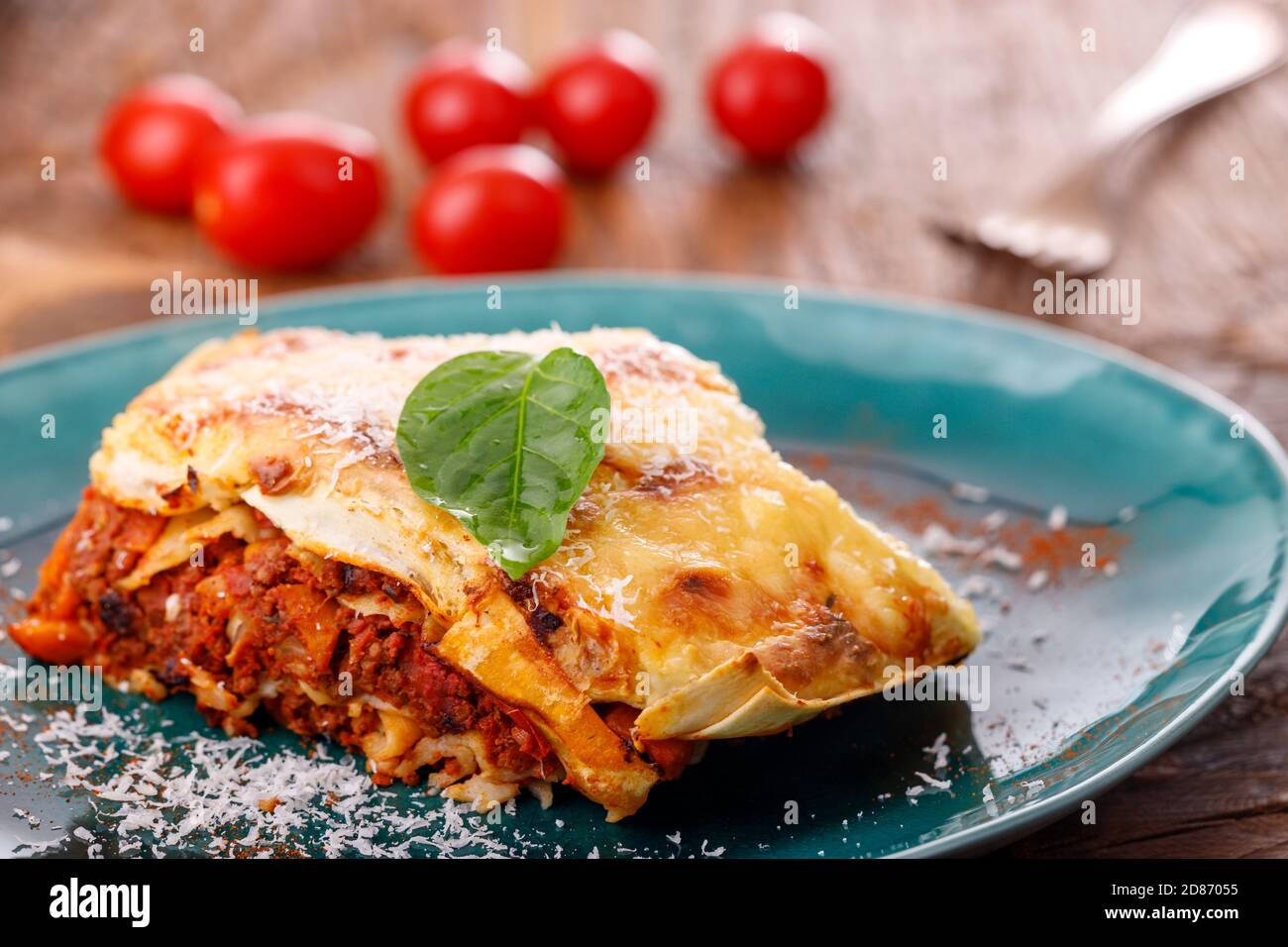 Portion italienische Lasagne auf einem blauen Teller Stockfoto