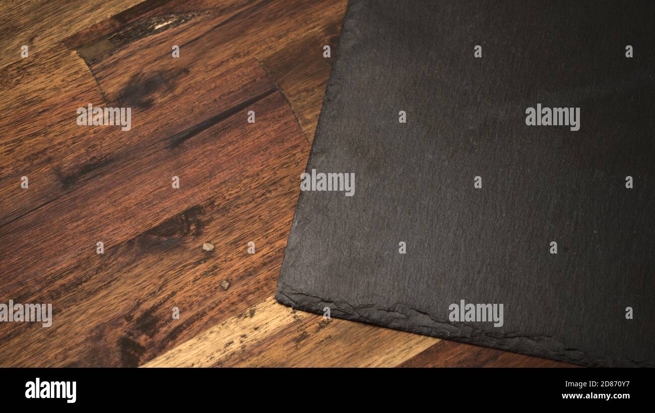 Servierplatte aus dunklem Schieferstein auf Holz Stockfoto