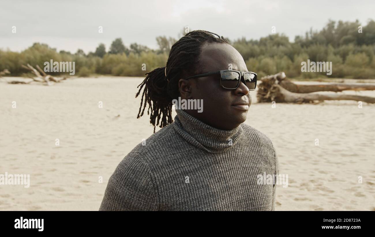 Porträt eines jungen schönen afroamerikanischen schwarzen Mannes am Sandstrand im Winter. Hochwertige Fotos Stockfoto
