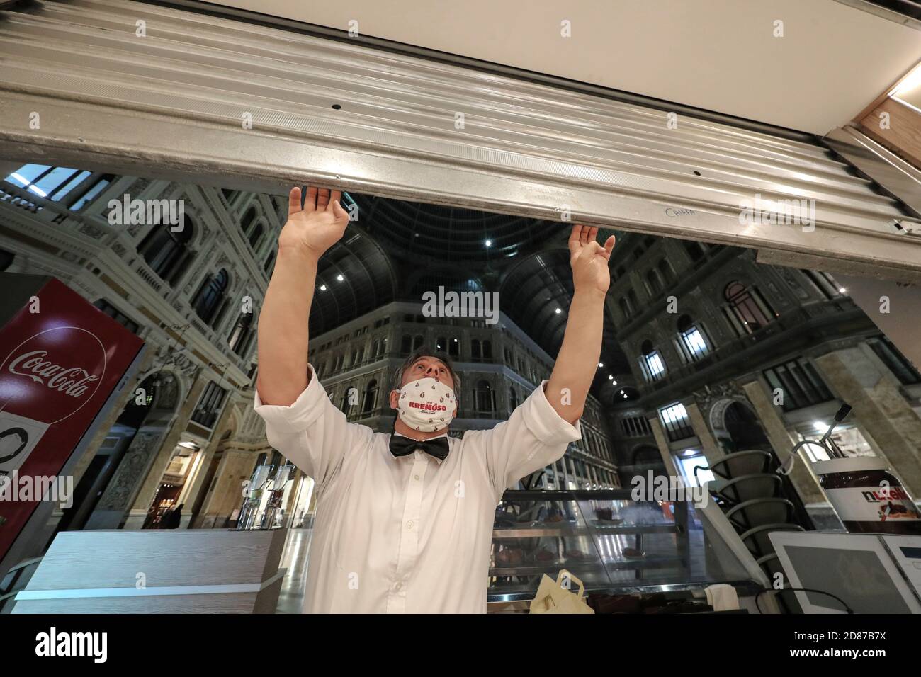 Neapel, Italien. Oktober 2020. Ein Kellner mit Schutzmaske schließt die Bar in der Galleria Umberto in Neapel. Ein Regierungserlass verhängte die Schließung von Restaurants, Bars und Geschäften um 18:00 Uhr und eine Ausgangssperre ab 23:00 Uhr, um die Ausbreitung der Covid-19-Krankheit zu stoppen.Kredit: Unabhängige Fotoagentur/Alamy Live News Stockfoto