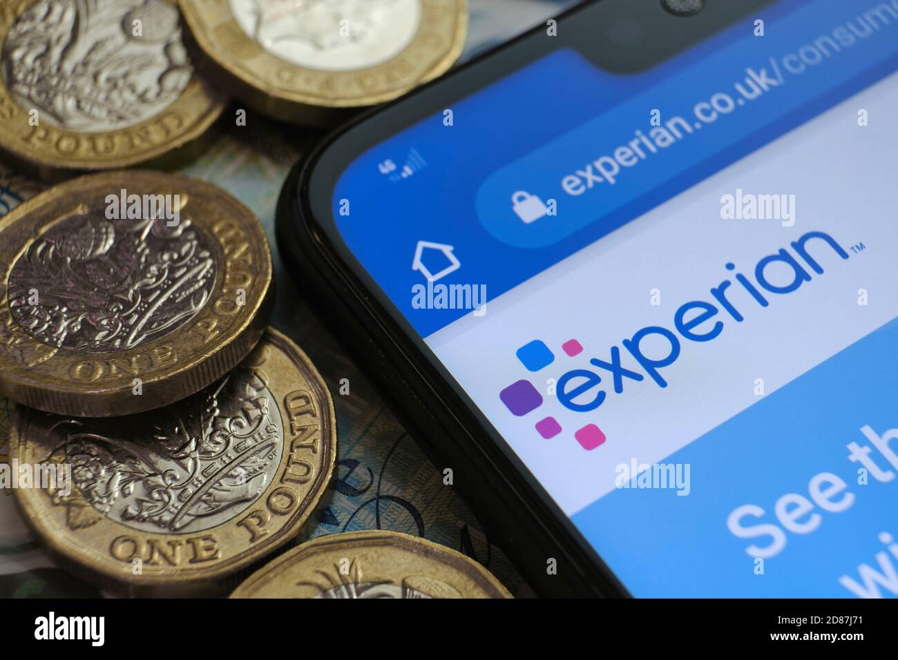 Experian Credit Check Agentur Logo auf der Webseite auf der Ecke des Smartphones in der Nähe von Pfund-Münzen platziert gesehen. Selektiver Fokus. Stockfoto