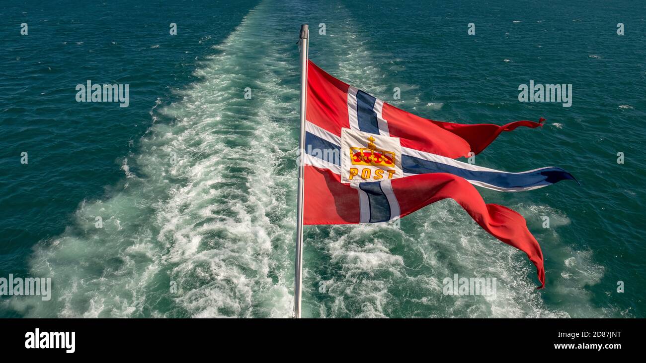 Das Postsymbol auf der norwegischen Flagge eines Hurtigruten-Schiffes, Schaumspray, Trondheimfjord, Agdenes, Trøndelag, Norwegen, Skandinavien, Europa, Abenteuer Tri Stockfoto