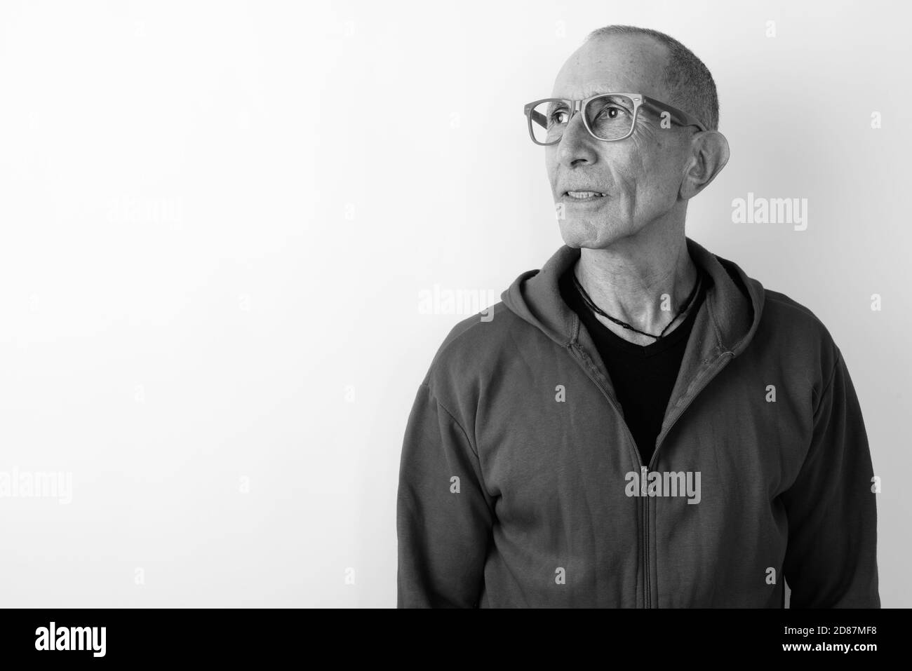 Studio shot der kahlen älterer Mann denken beim Tragen von Brillen vor weißem Hintergrund Stockfoto