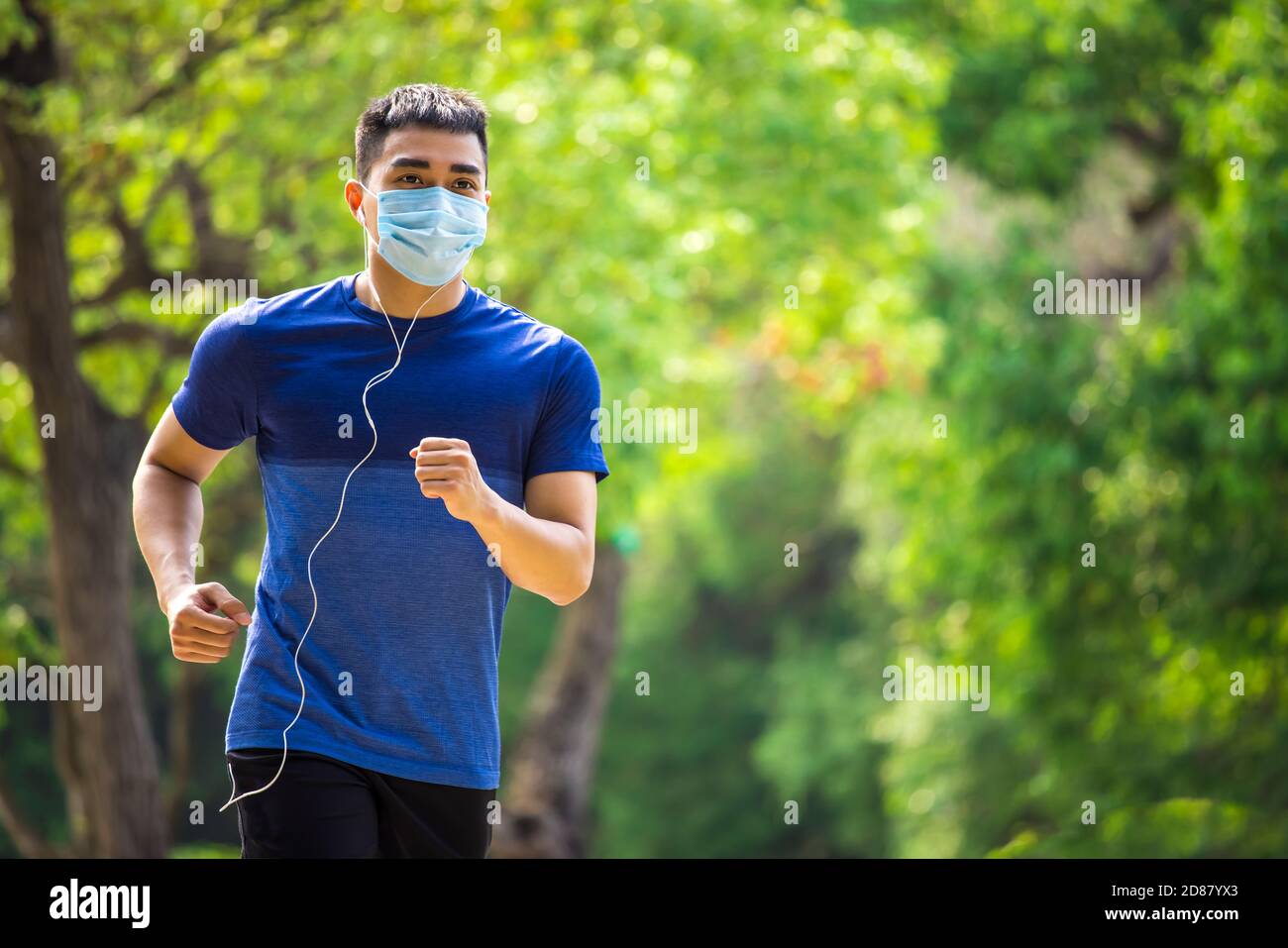 Mann in Gesichtsmaske und läuft im Park Stockfoto