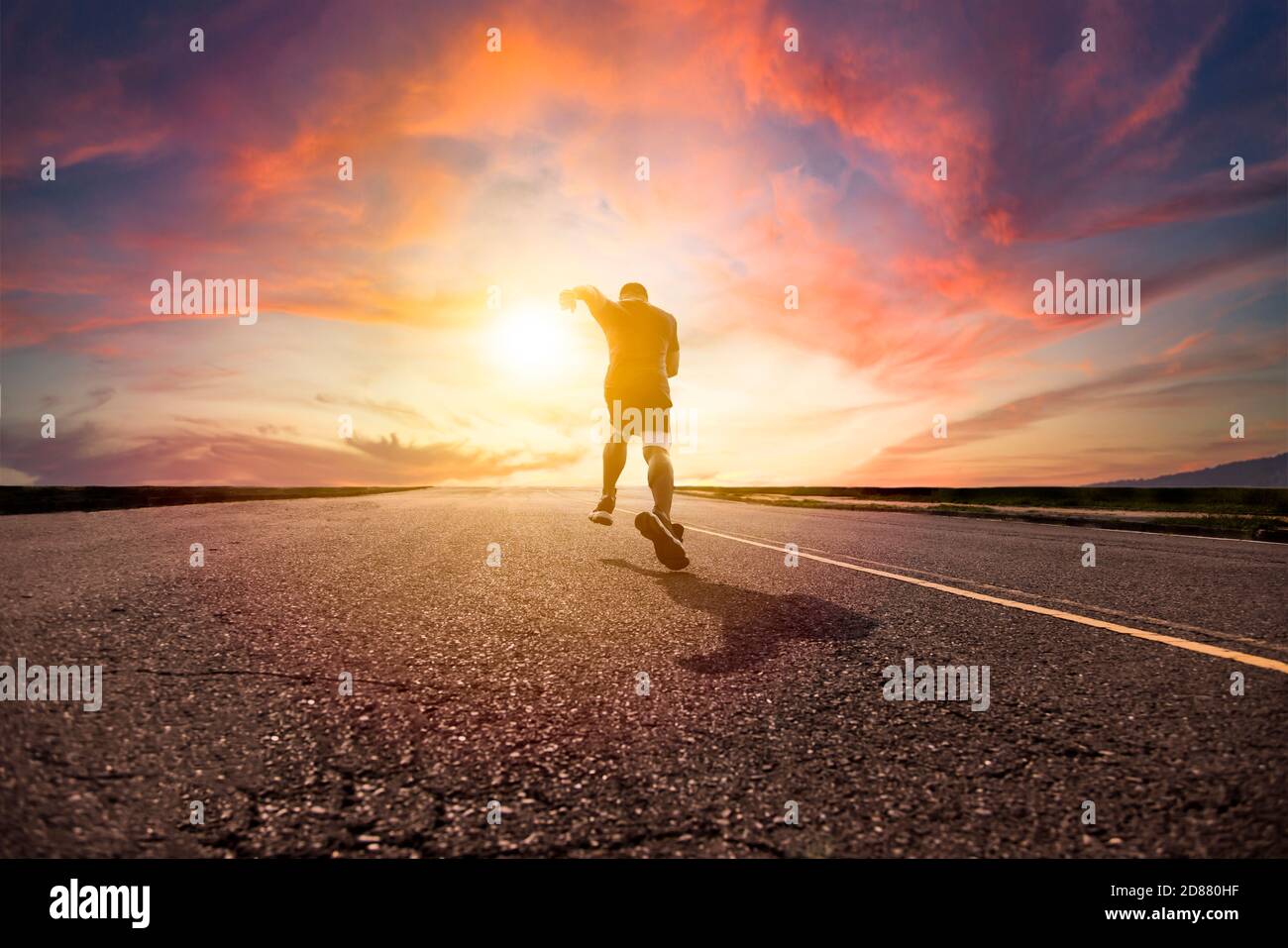 Mann läuft und sprintet auf der Straße mit Sonnenuntergang Hintergrund Stockfoto