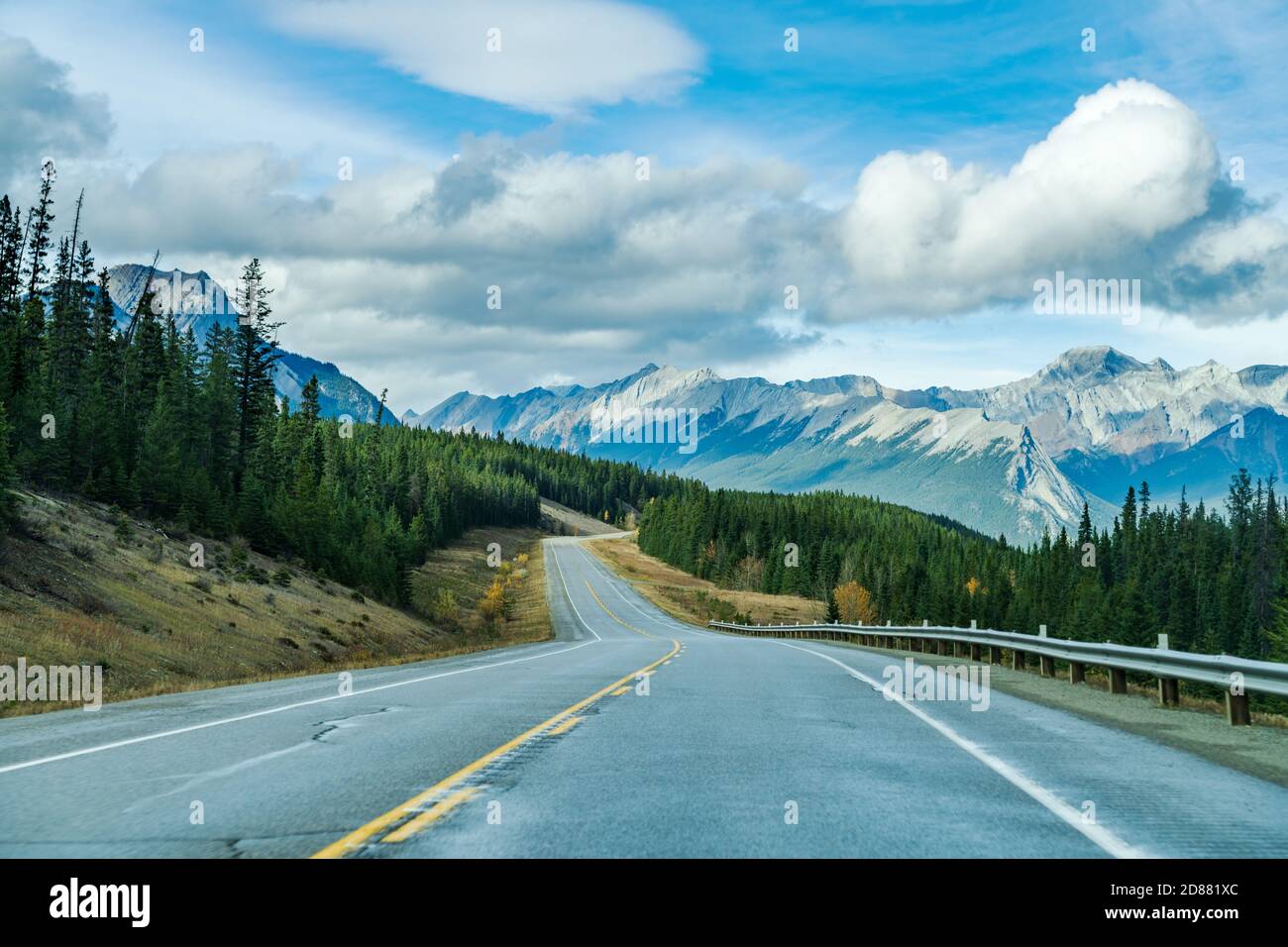 Landstraße im Wald mit Bergen im Hintergrund. Alberta Highway 11 (David Thompson Highway), Jasper National Park, Kanada. Stockfoto