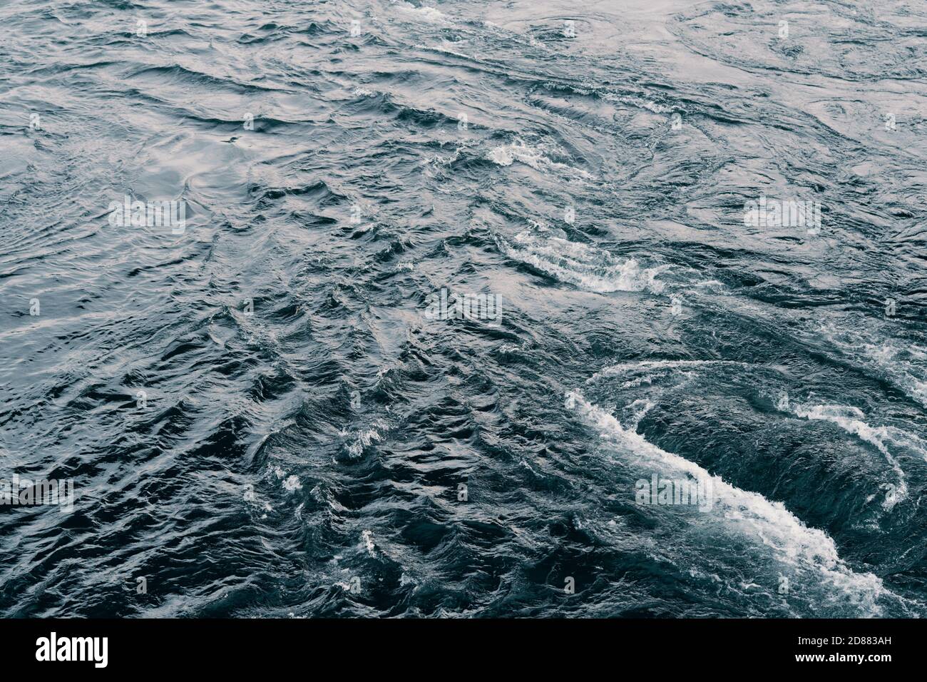 Blaue Wasserstruktur auf dunklem Hintergrund. Hintergrundbild. Aufnahme der Wasseroberfläche des Meeresflusses Stockfoto