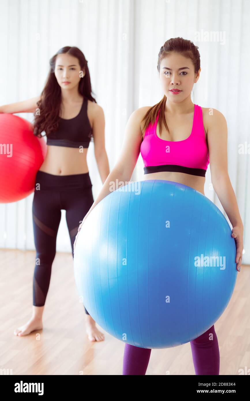 Zwei gesunde Frauen halten Fit Ball in der Fitness-Gym-Gruppenübung. Sport Lifestyle-Konzept. Stockfoto