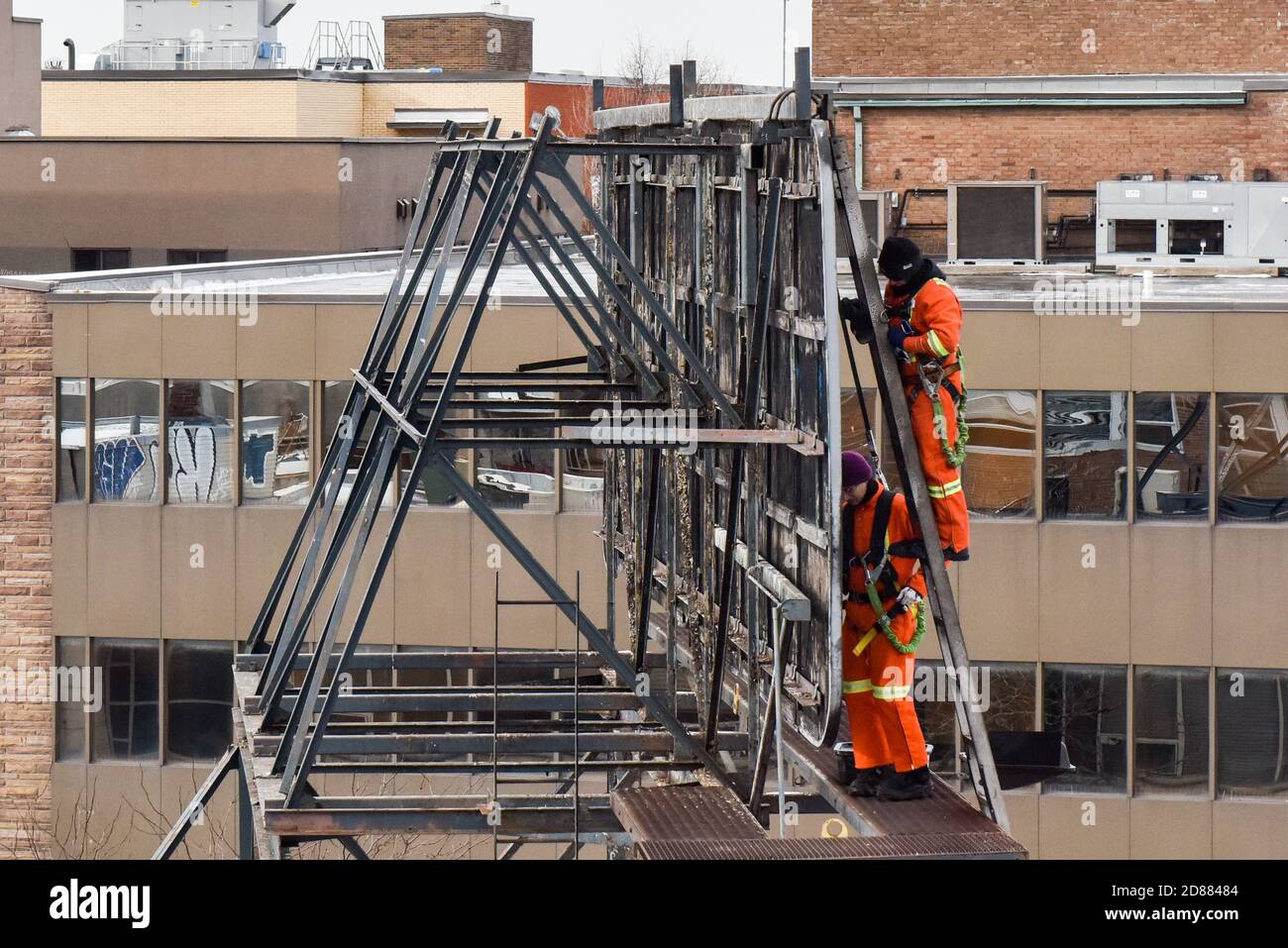 Arbeiter ändern die Anzeige auf einer Plakatwand auf der Oberseite Eines Gebäudes in Montreal Stockfoto Arbeiter ändern die Anzeige auf einer Plakatwand auf der Oberseite Eines Gebäudes in Montreal Stockfoto