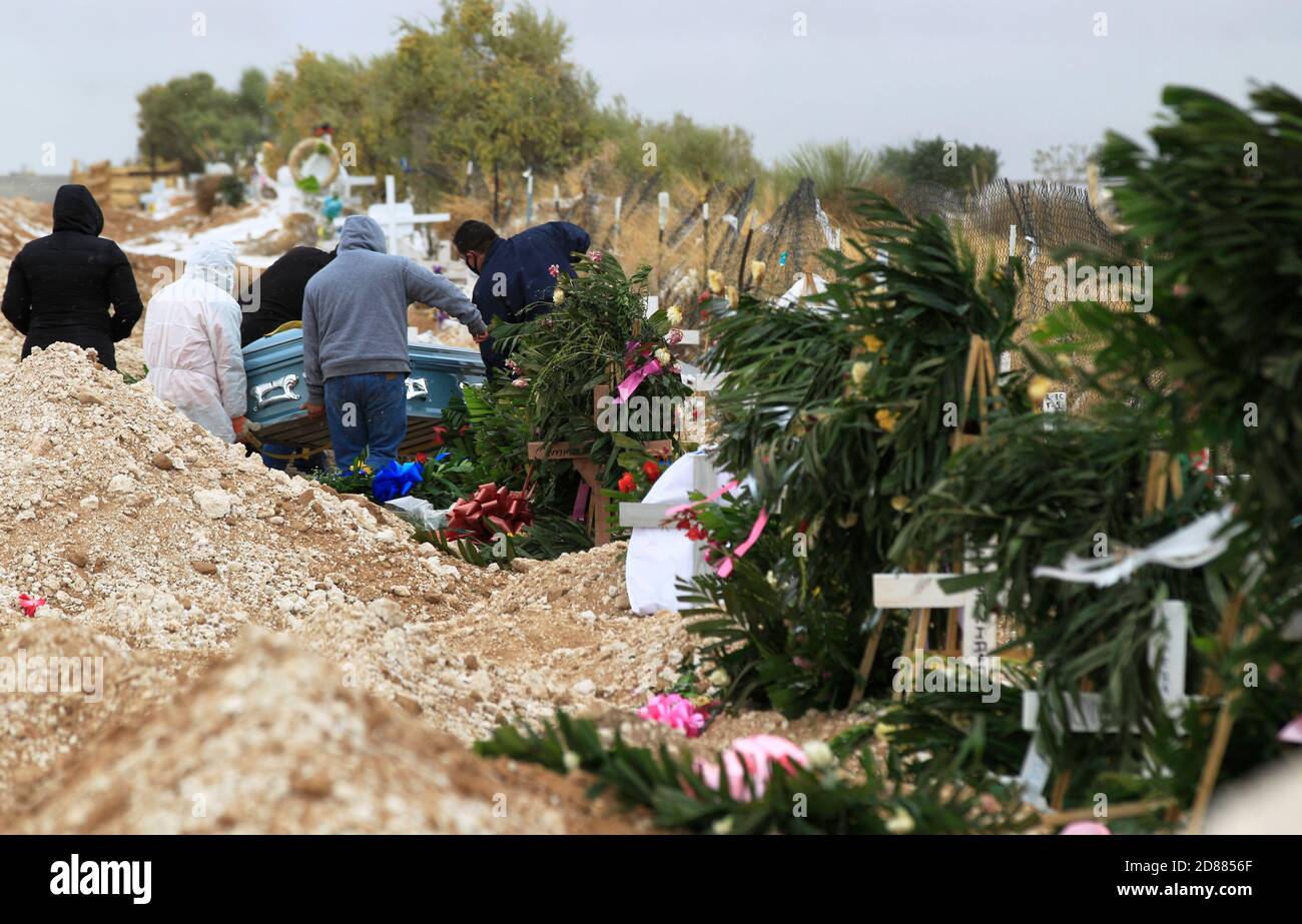 Ciudad Juarez, MEXIKO. Oktober 2020. Friedhofsarbeiter begraben die Leichen von Menschen, die mit COVID-19 infiziert wurden, in Ciudad Juarez, als eine Rauchsäule aus dem Krematorium des städtischen Friedhofs San Rafael aufsteigt. COVID-19 Opfer werden in einem separaten Teil des Friedhofs begraben. Heute erreichte Mexiko insgesamt 900,000 Fälle und fast 90,000 Todesfälle durch COVID-19. Quelle: Corrie Boudreaux/Alamy Live News Stockfoto