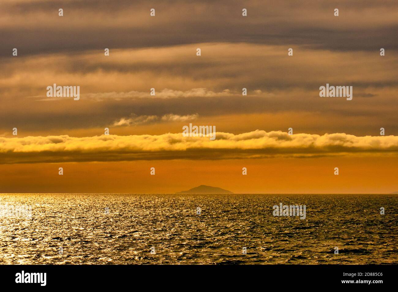 Segeln Sie bei Sonnenuntergang über die Cook Strait mit einem dramatischen Orange Himmel auf der Inter Islander Fähre Stockfoto