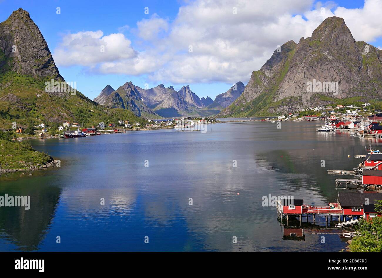 Scharfe Berge, rote Hütten und Fischerboote spiegeln sich in den Fjord in reine, Lofoten Islands, Norwegen Stockfoto