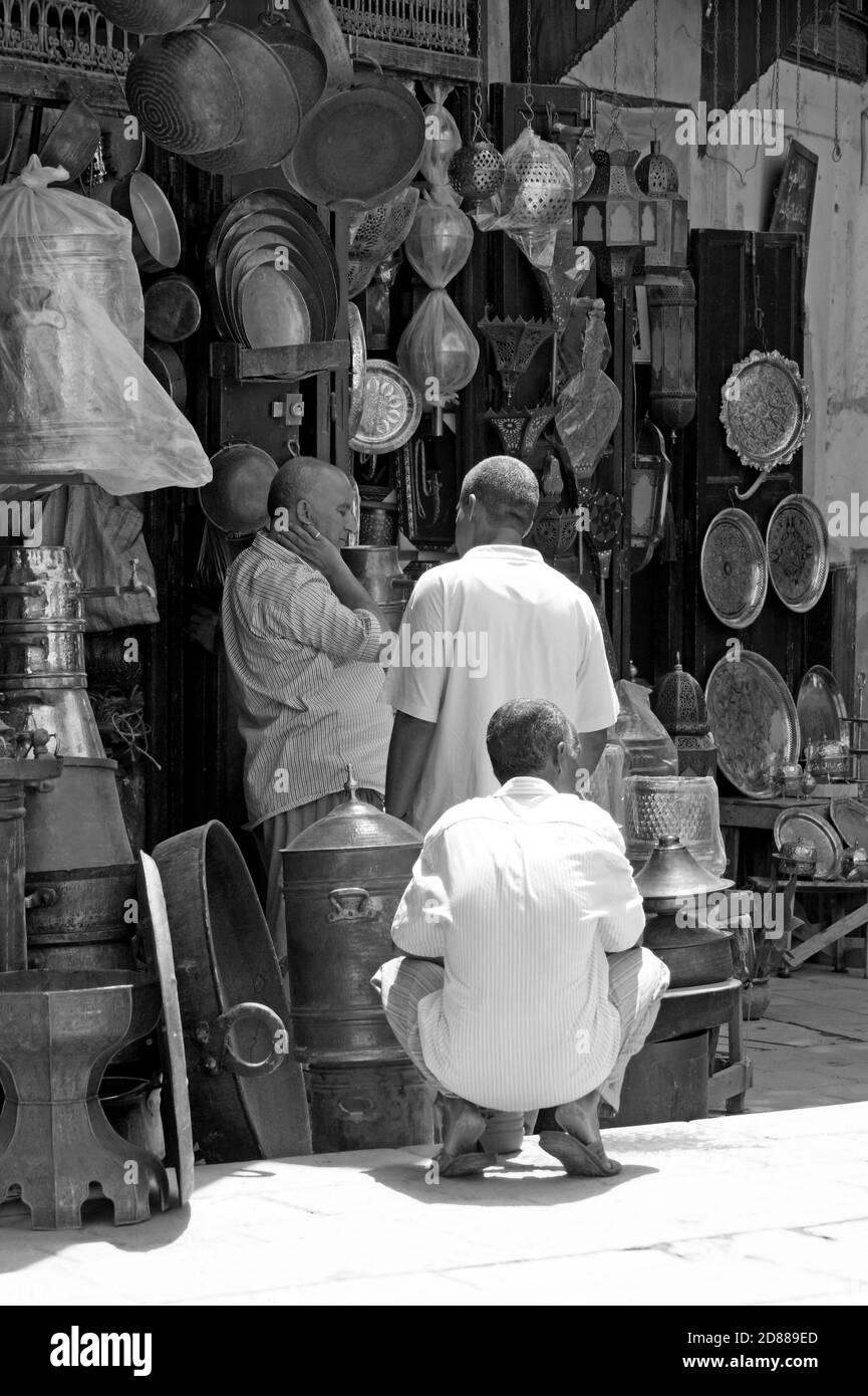 Im Souk treffen sich drei Schwarzweiß-Männer auf dem Place Seffarine Square in Fès, Marokko, bekannt für seine Kupferschmiede und Metallarbeiter. Stockfoto