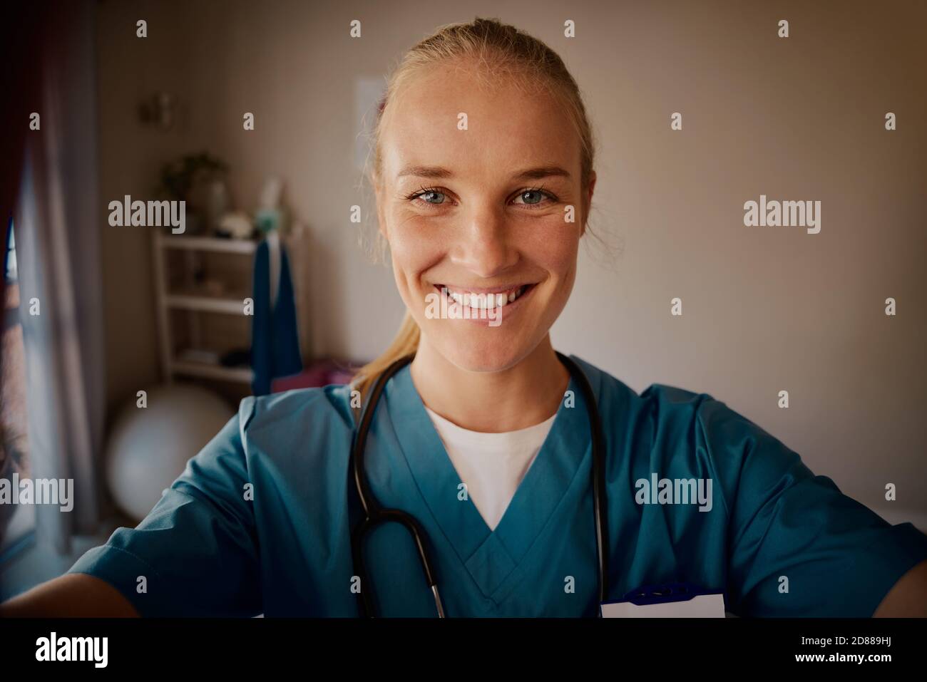 Porträt einer lächelnden Ärztin in Uniform mit Stethoskop in Nackenschauen auf die Kamera Stockfoto