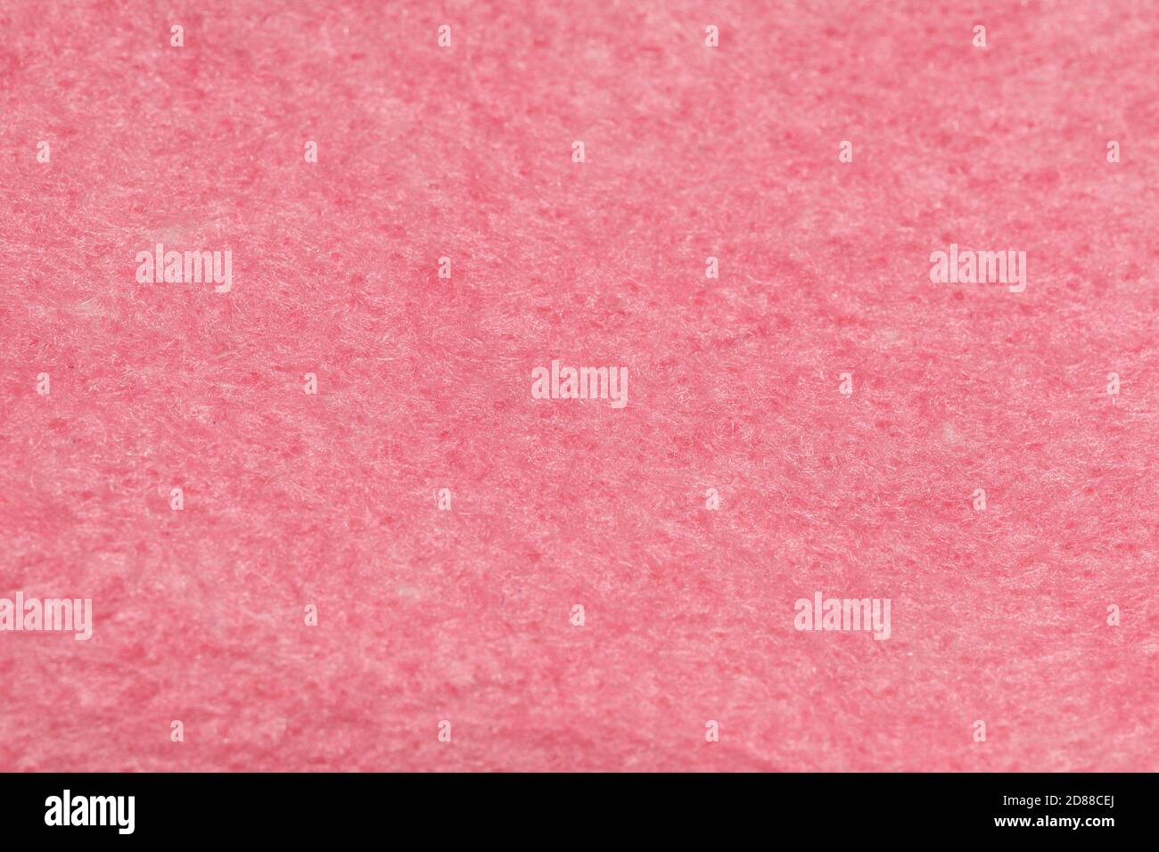 Samtstruktur aus Korallenkwoll-Filz. Feiner rosa matter Hintergrund aus Wildleder Stoff. Stockfoto