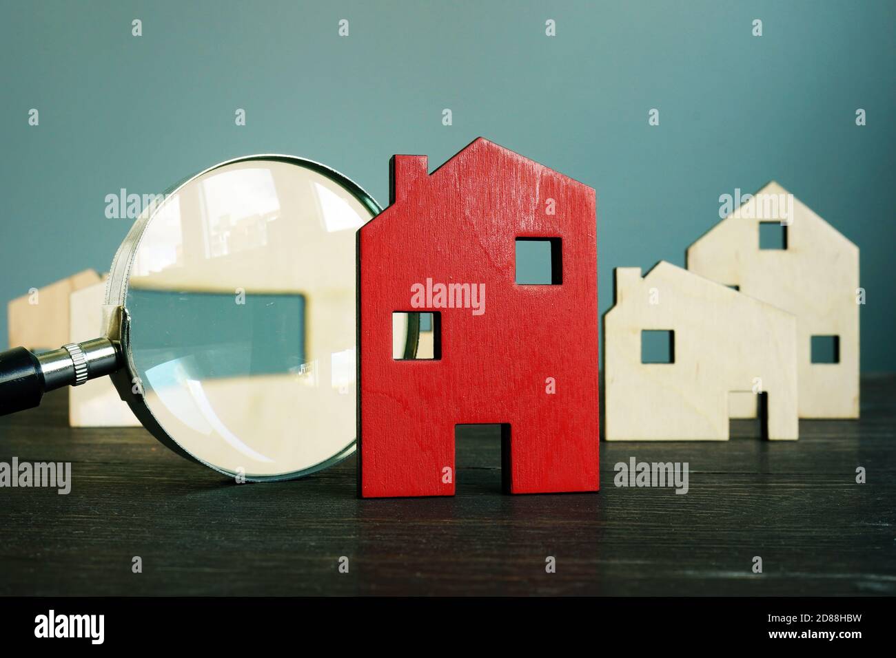 Schätzen des Wertes von Immobilien. Kleines Haus und Lupe. Stockfoto