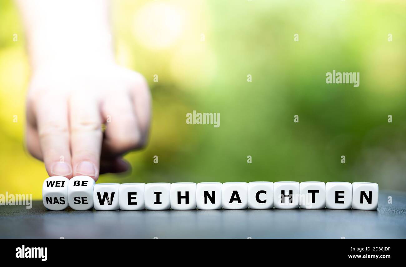 Weiße oder nasse Weihnachten? Hand dreht Würfel und ändert den Ausdruck "Wet Christmas" zu "White Christmas". Stockfoto