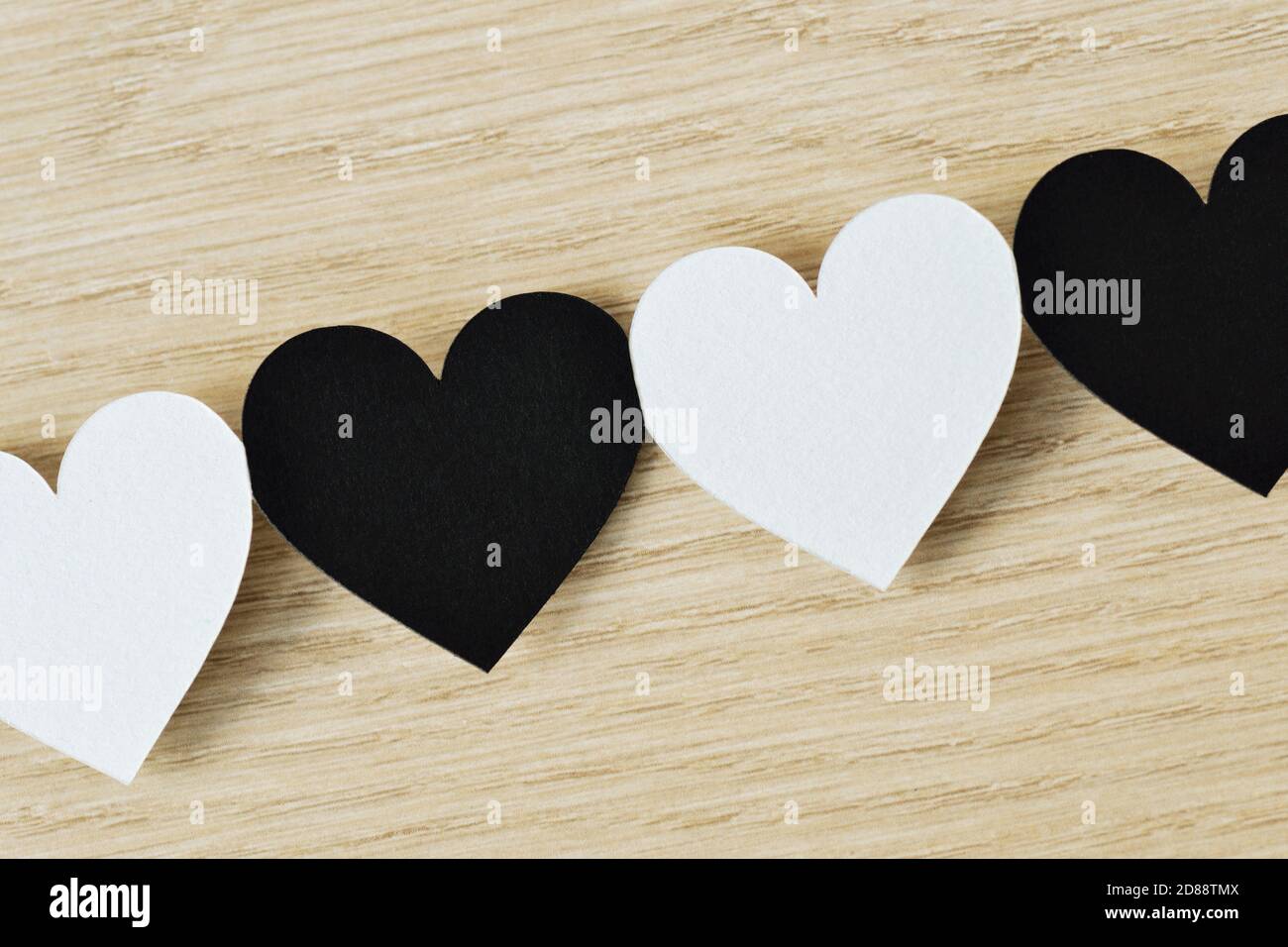 Schwarze und weiße Herzen in einer Kette miteinander verbunden - Anti-Rassismus-Konzept Stockfoto