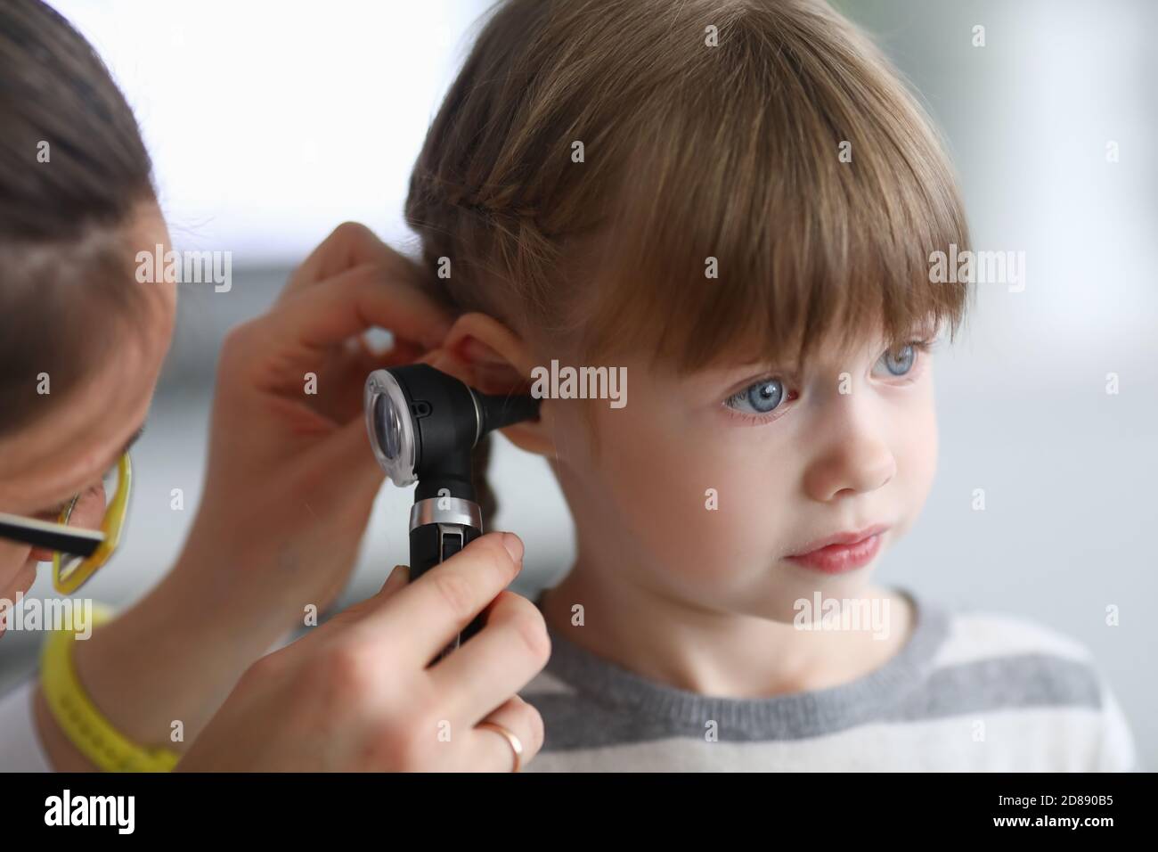 Otorhinolaryngologe untersucht kleine Mädchen Ohr mit Otoskop in der Klinik Stockfoto