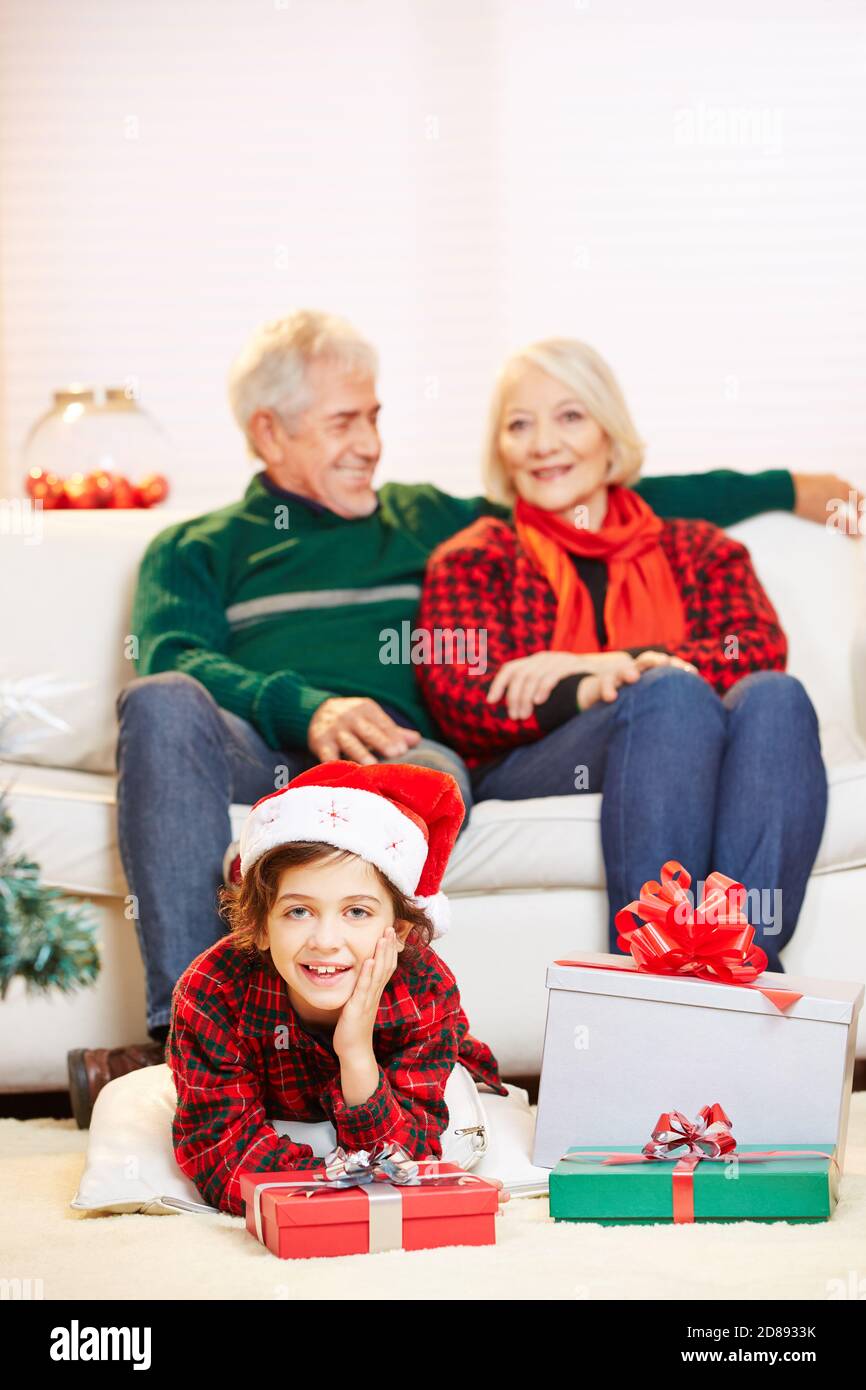 Glückliches Kind mit Geschenken von Großeltern zu Weihnachten Stockfoto